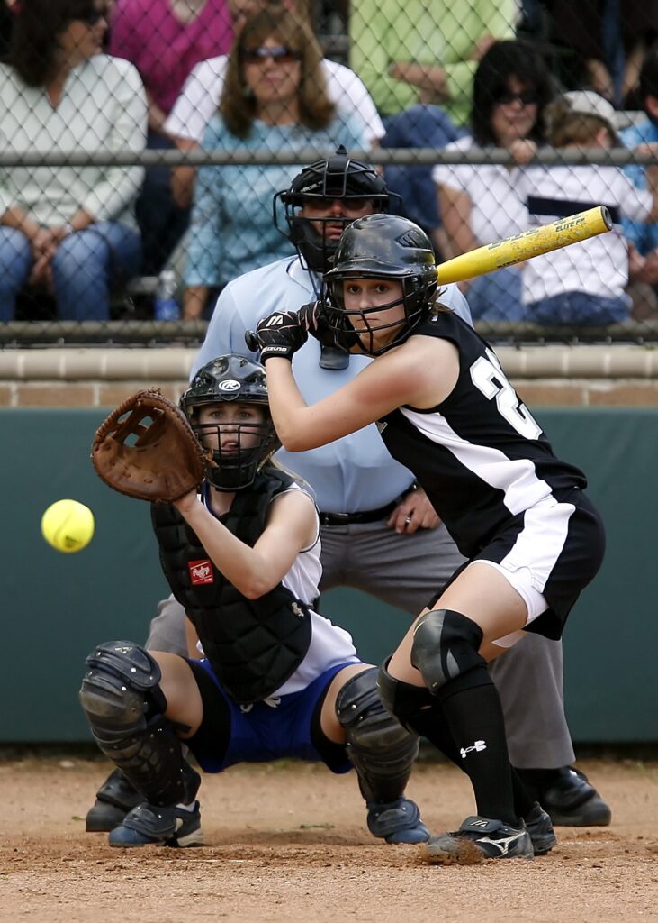 Female baseball player at bat about to swing